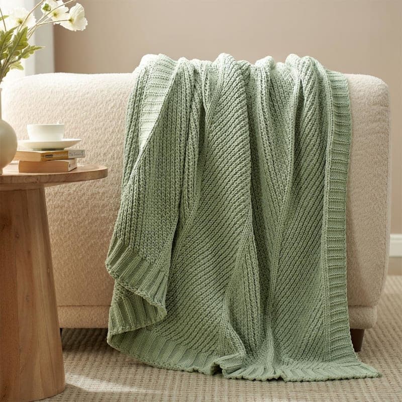 Sage green chunky knit chenille throw blanket styled on a chair for cozy living room decor gallery view 4