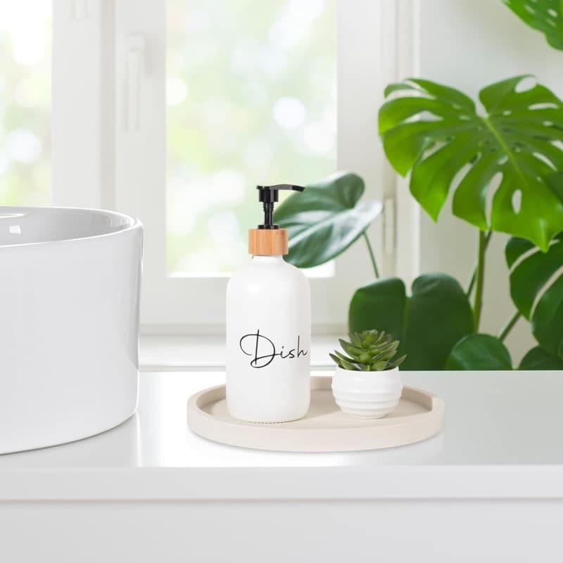 Round beige silicone organizer tray styled with a candle, diffuser, and decorative vase for a bathroom vanity or coffee table. gallery view 2