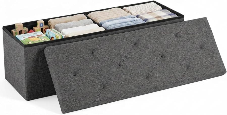 Grey fabric storage ottoman bench with padded tufted lid for bedroom, living room, and entryway organization.