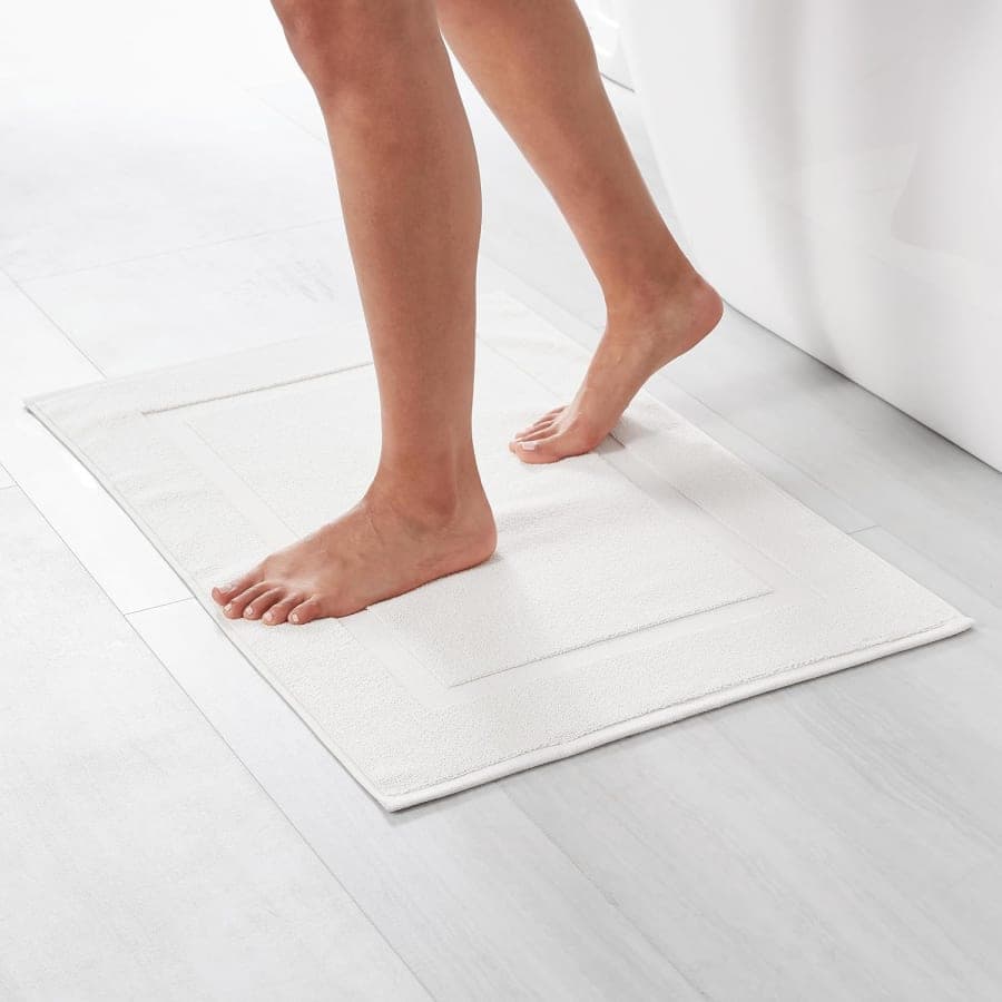 Bright white cotton non-slip bath mat for a clean spa-style bathroom floor