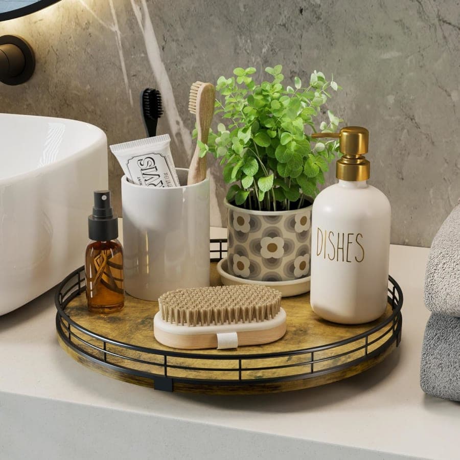 Rustic wood lazy Susan organizer holding bathroom essentials, a soap dispenser, brushes, and a small plant beside a sink.